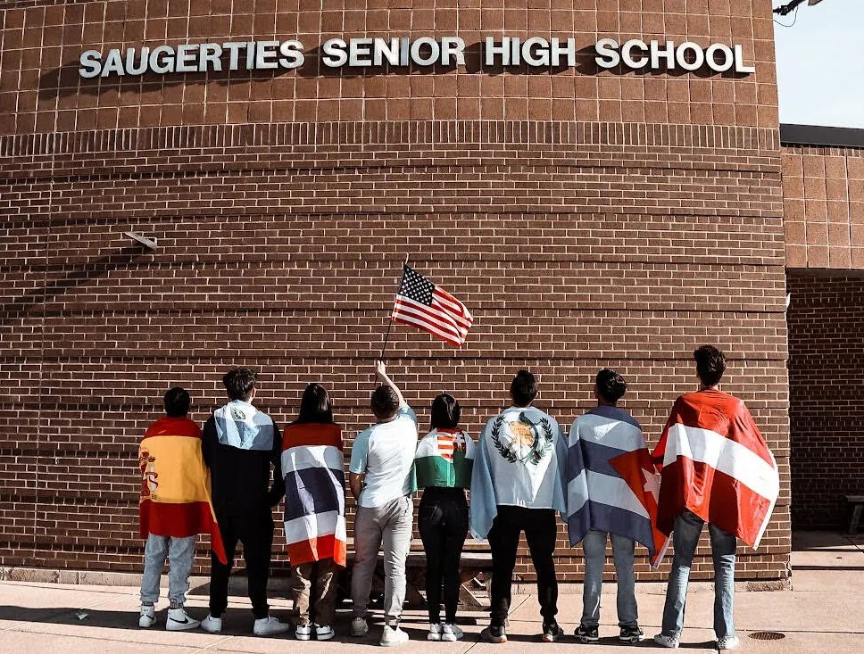 Image of high school students with national flags and United States flag credit Adile Jones